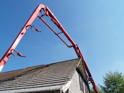 De betonpomp reikt tot ver boven de woning