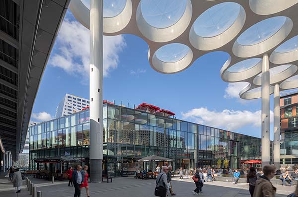 Transparant Retailpaviljoen bovenop treinsporen naast Utrecht CS